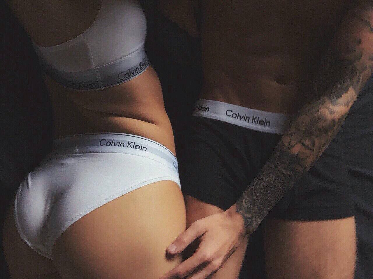 Задний вид девушки в тонком белье Calvin Klein, изогнувшейся спиной